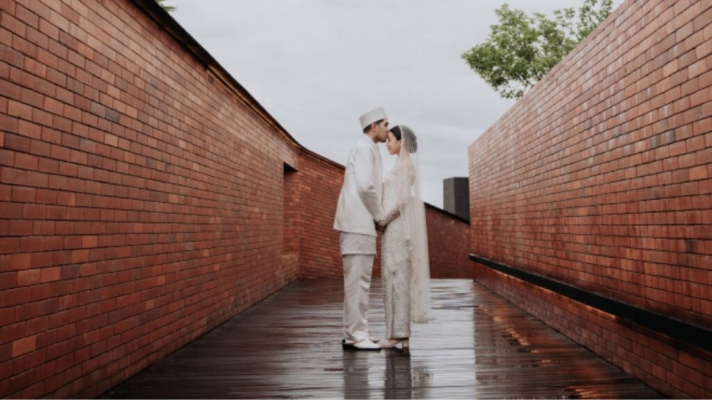 Wedding couple walking through a rain-soaked Ubud venue