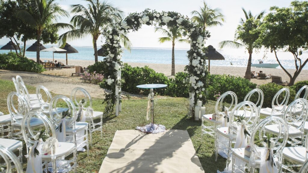 White parasols arranged along an outdoor wedding ceremony aisle