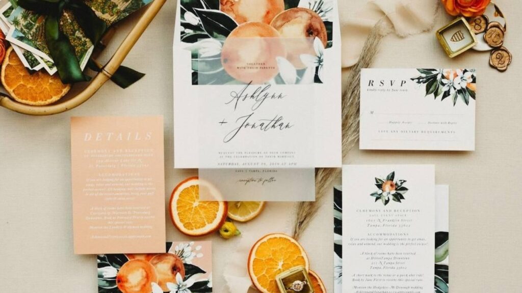 Wedding stationery and personalized guest cards arranged with floral and citrus details