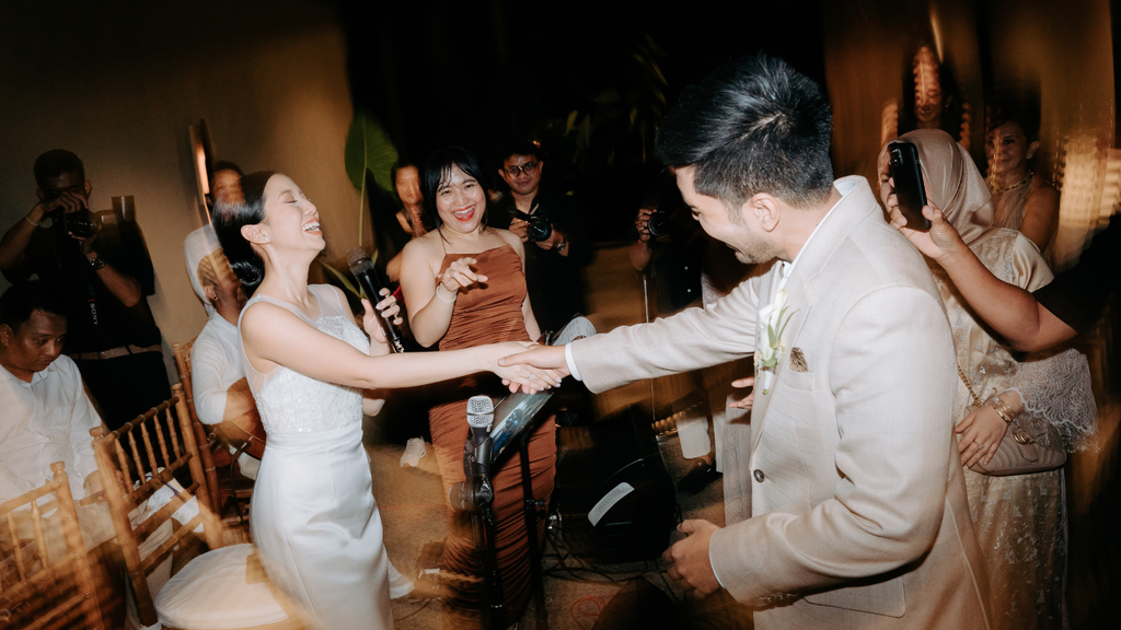 Newlywed couple dancing and celebrating with guests during a lively wedding reception.